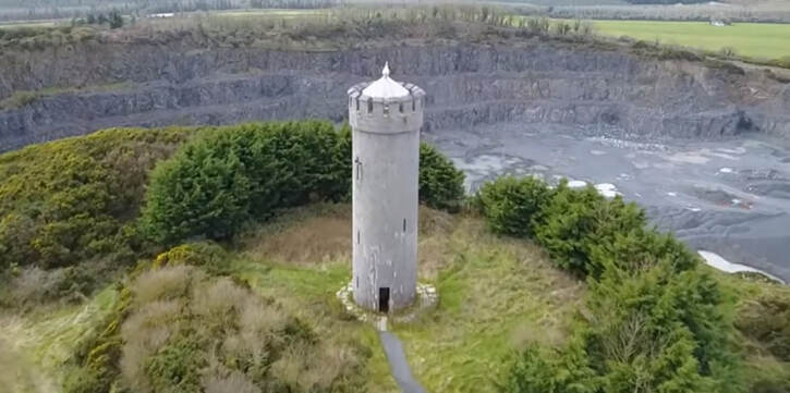 Round tower in Kildare Ireland beside stone quarry and surrounded by Trees