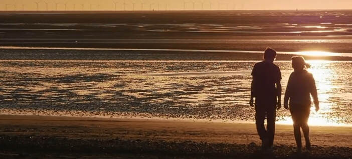 Couple walking on the beach in a romantic scene