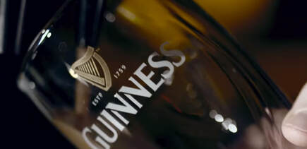 A Guinness beer glass showing the Irish harp badge