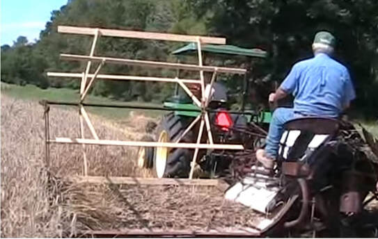 An old man working in a field on a tractor